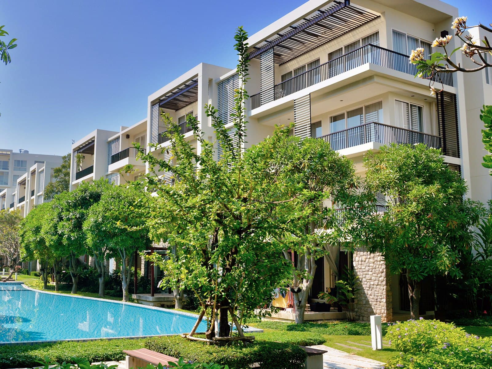 Illustrative condominium buildings around a landscaped pool