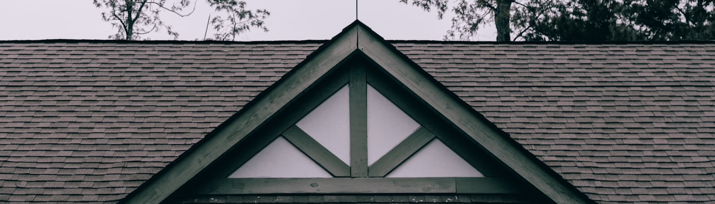 Illustrative roof gable against trees